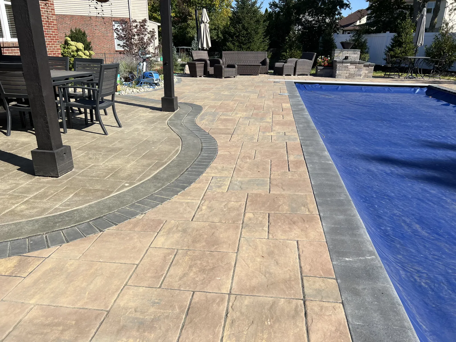 Covered dining area beside the pool on a paver terrace