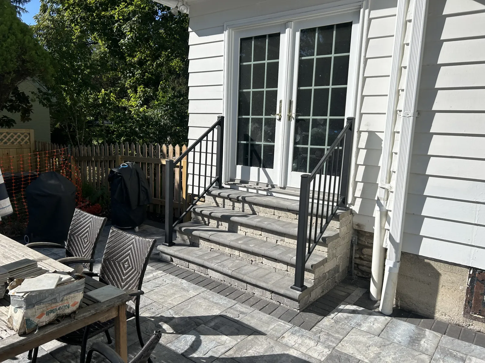 Paver patio and steps with black metal railing