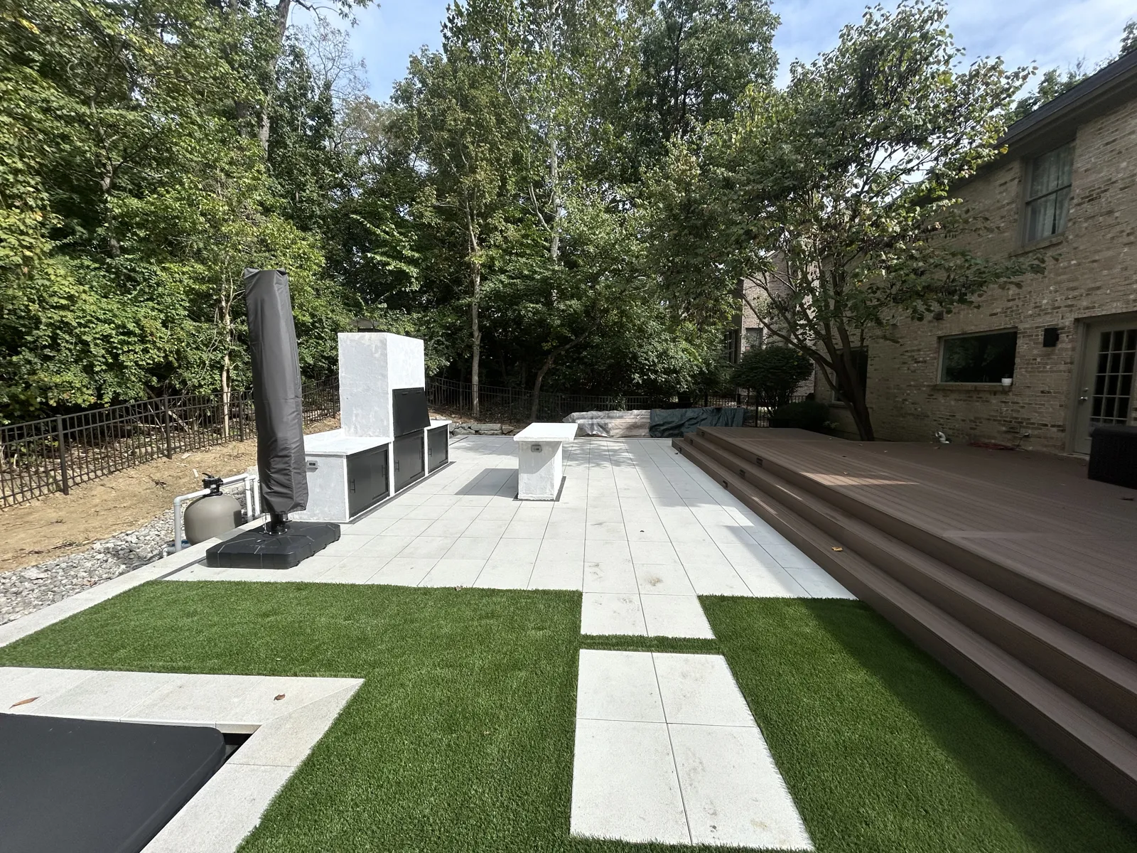 Composite deck stepping down to a paver terrace with a custom grill station