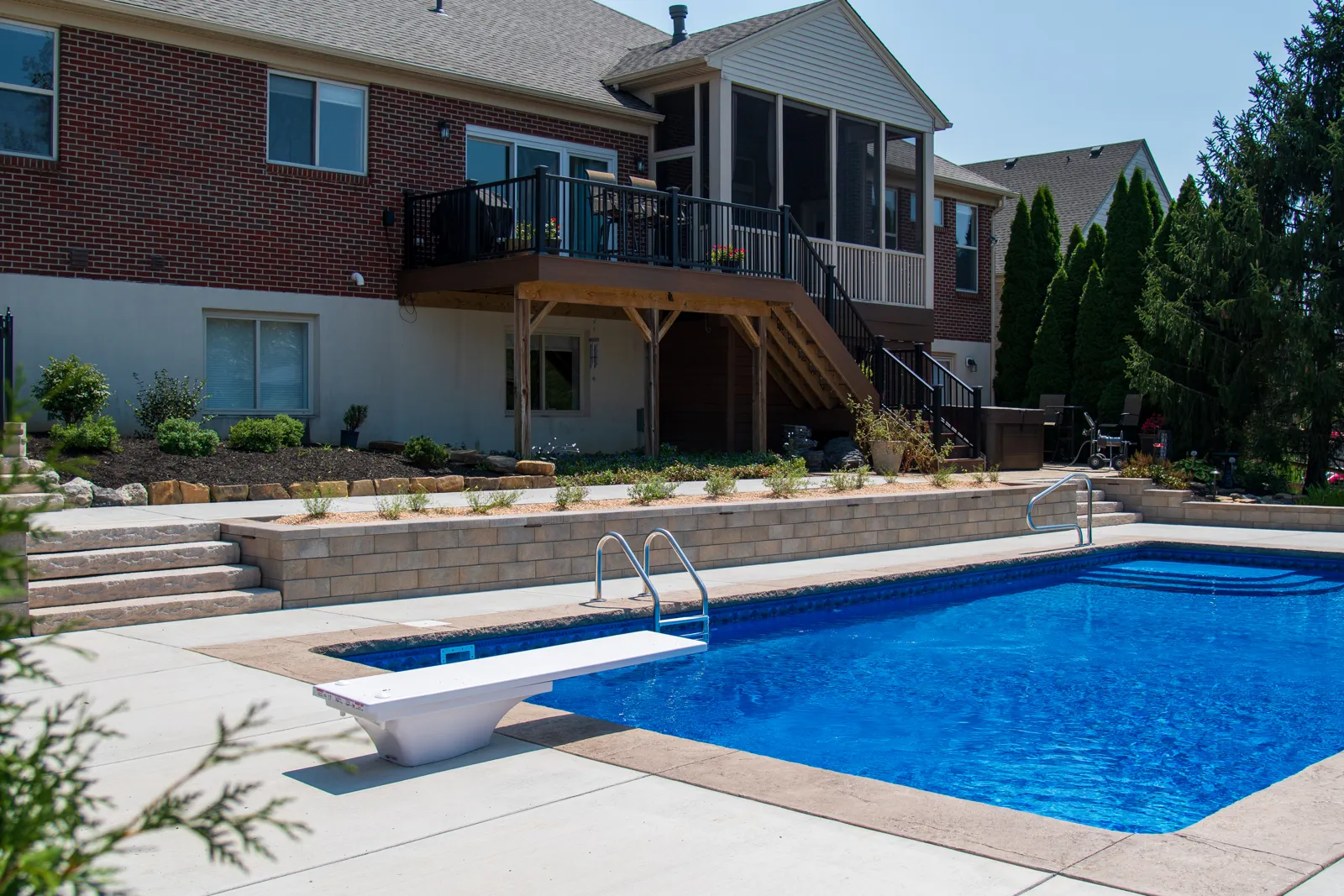Finished backyard with retaining wall, pool landscape and new plantings