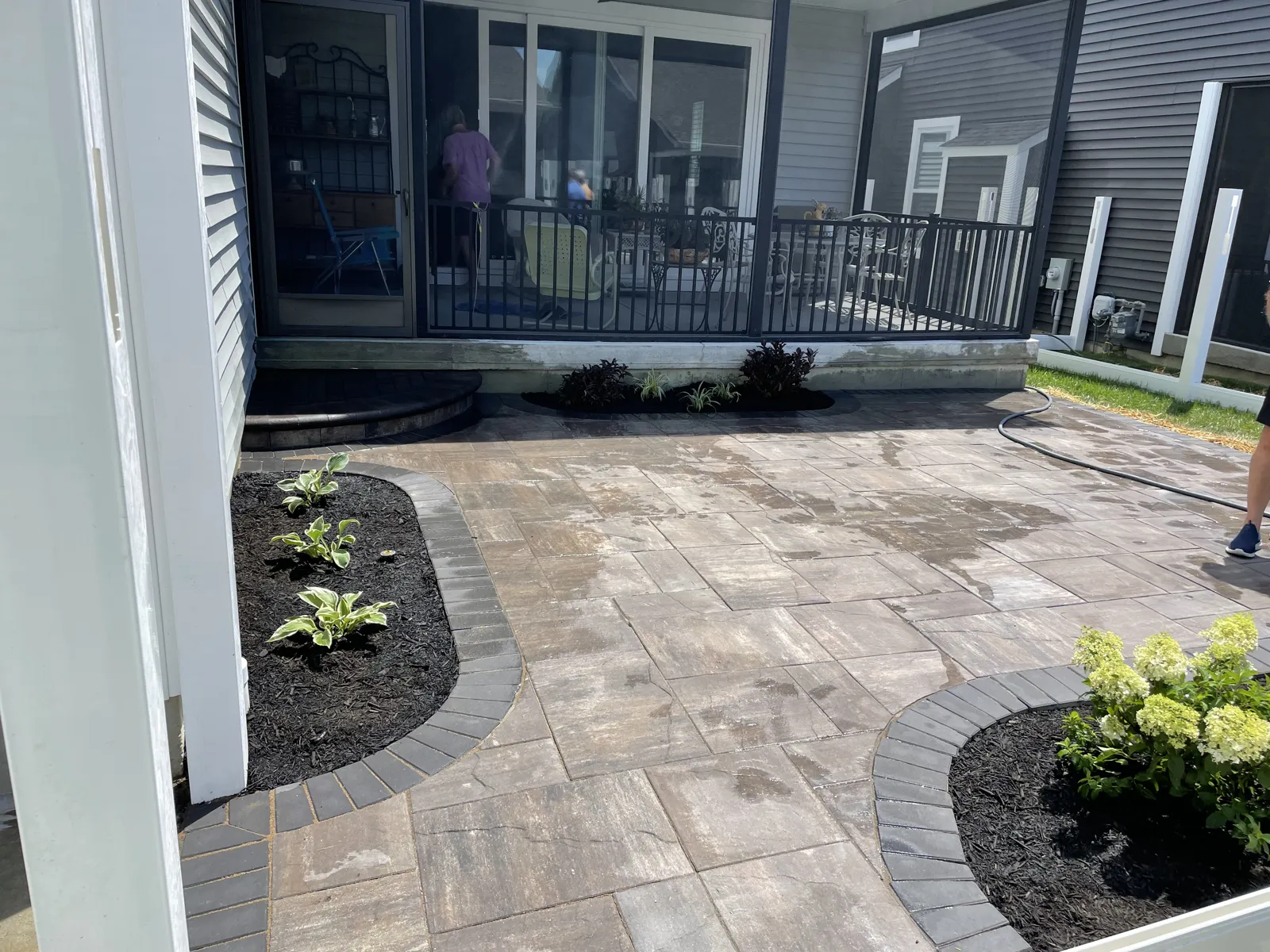 Paver patio with charcoal border and planting beds