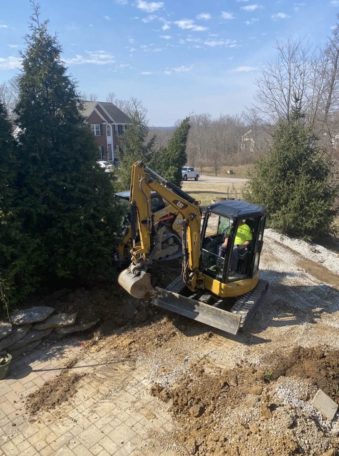 Tim Johnson operating a CAT excavator on a residential landscaping project