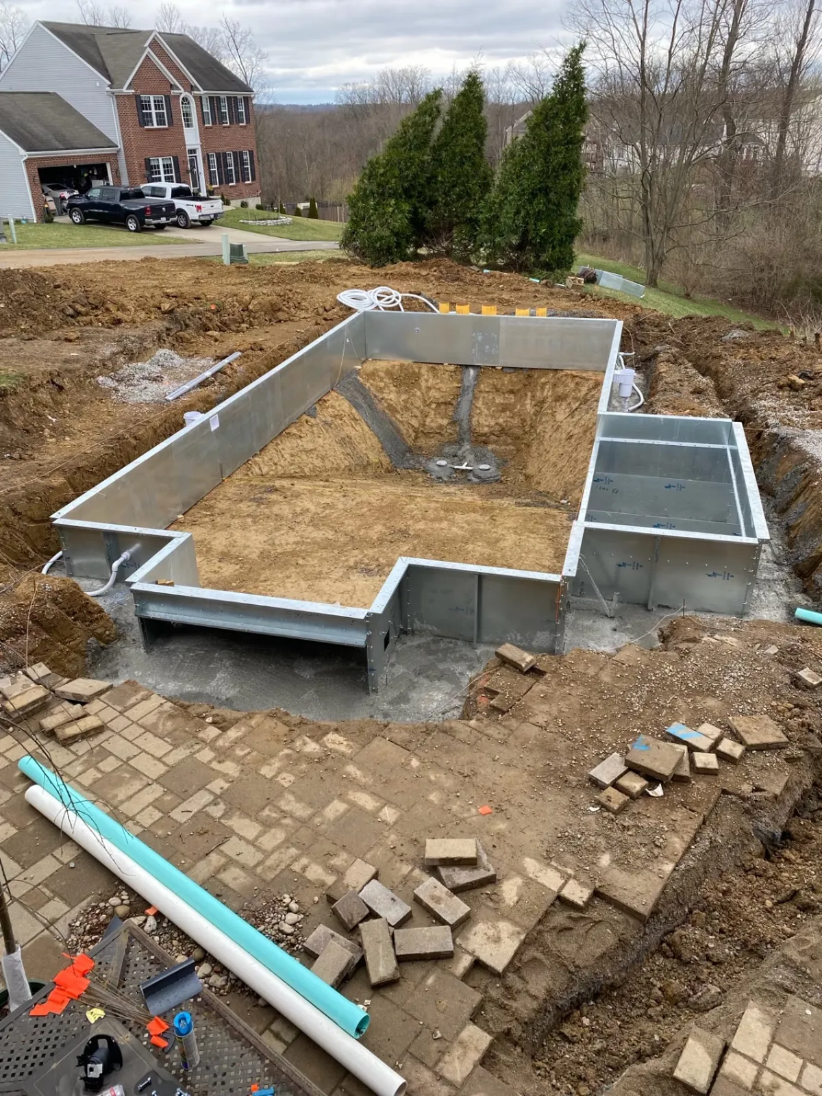 Excavated pool with steel wall panels and rough grading
