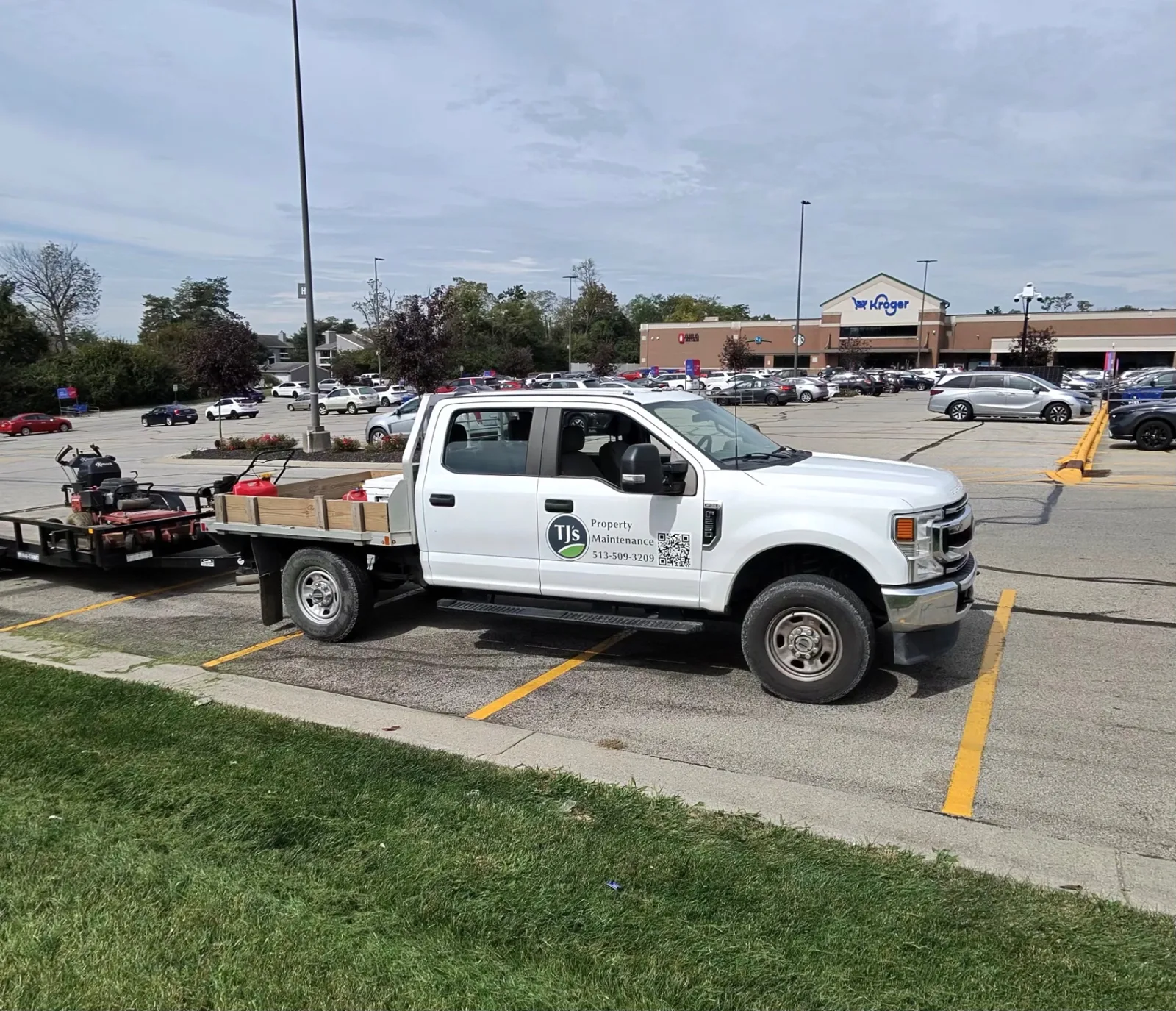 TJs Landscaping property maintenance truck and mower trailer at a Kroger anchored shopping center in Greater Cincinnati