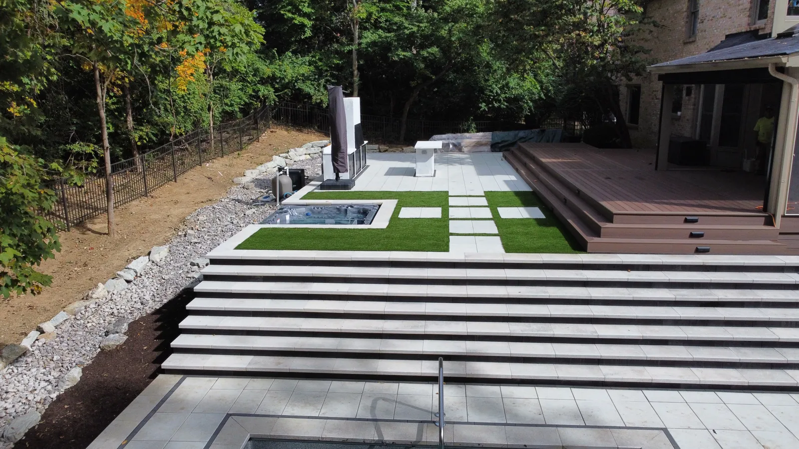 Massive multi-tier stone steps connecting the upper deck to the pool terrace