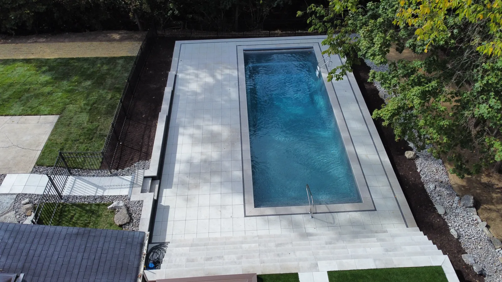 Overhead view of a large format paver pool surround with precise grading