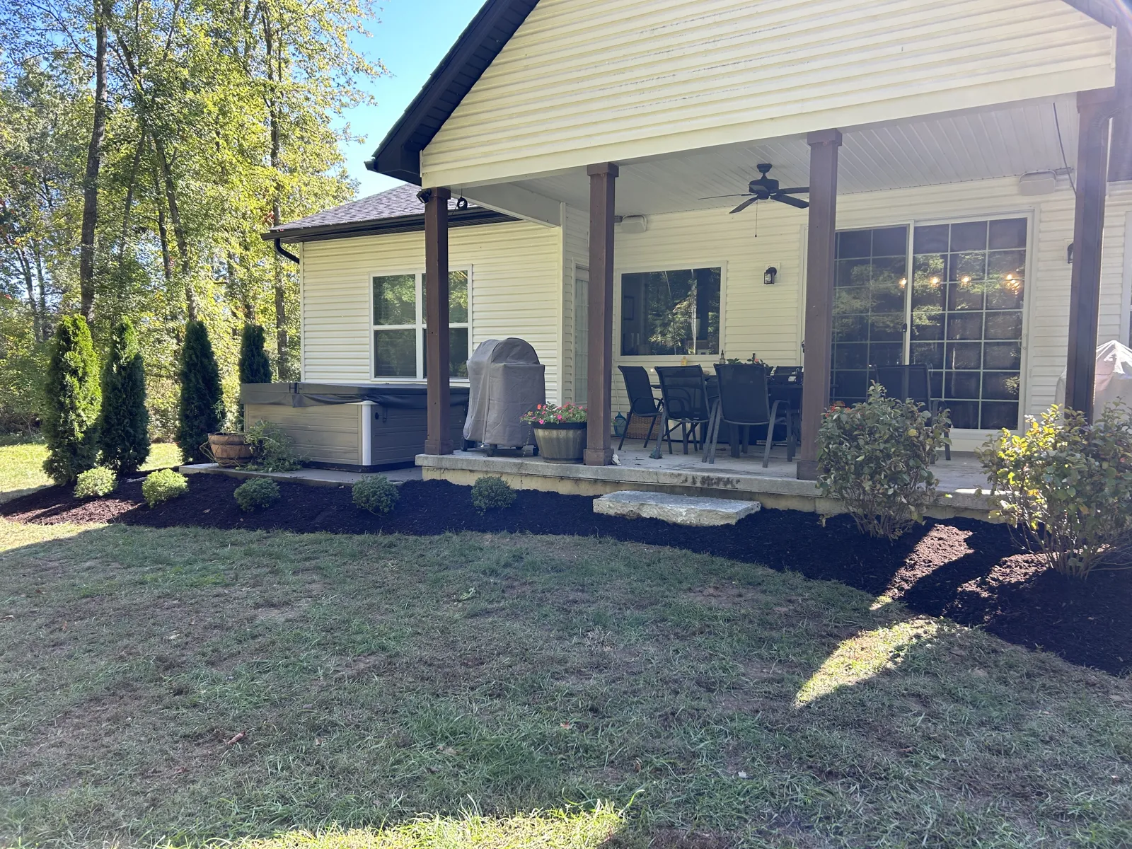 Fresh planting beds wrapping a covered patio