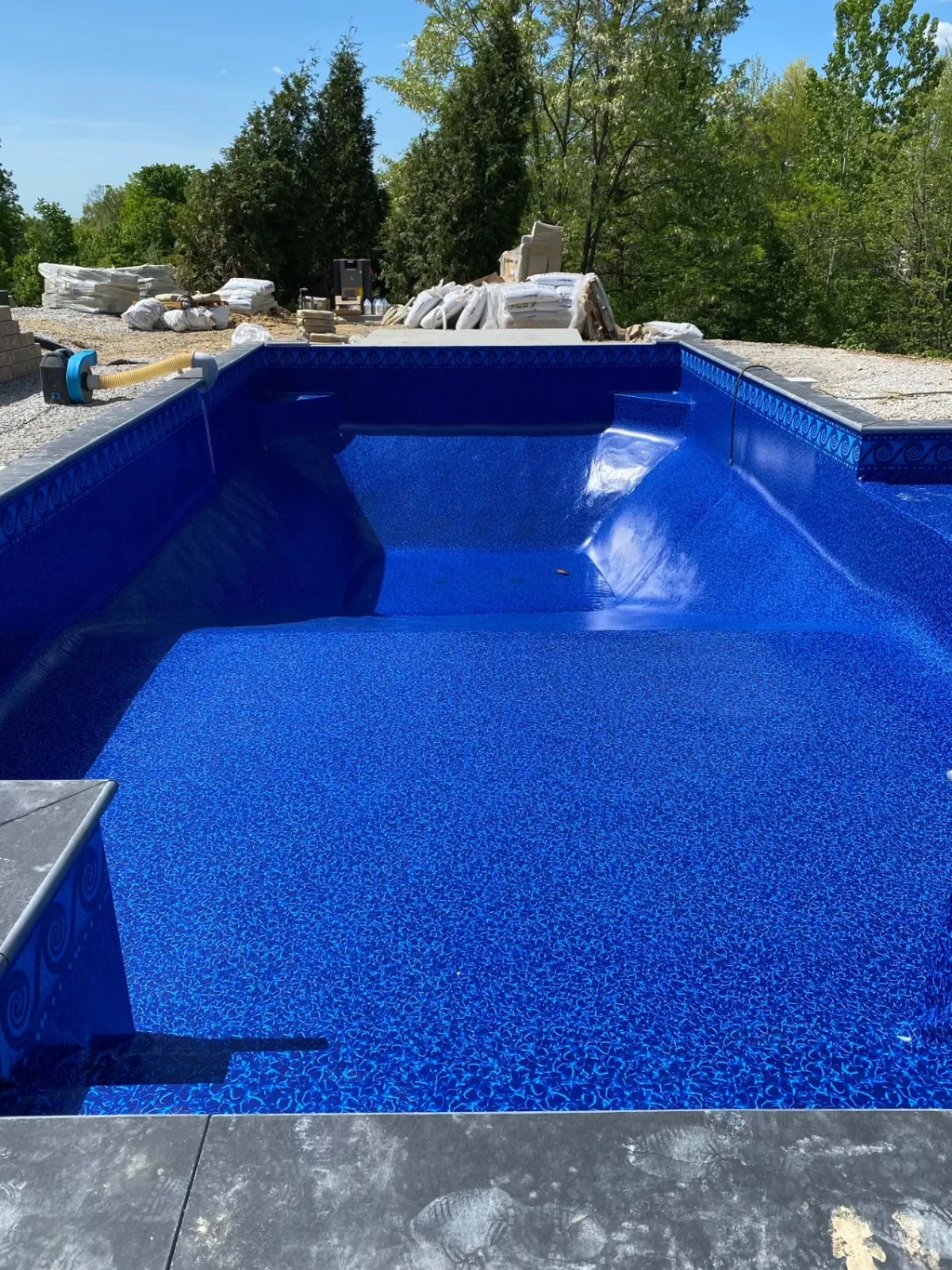 New blue pool liner with gravel base prepared for paver decking
