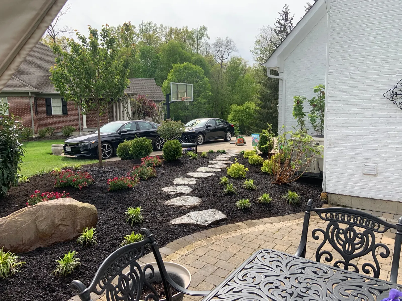 Flagstone steppers through dark mulch beds beside a patio