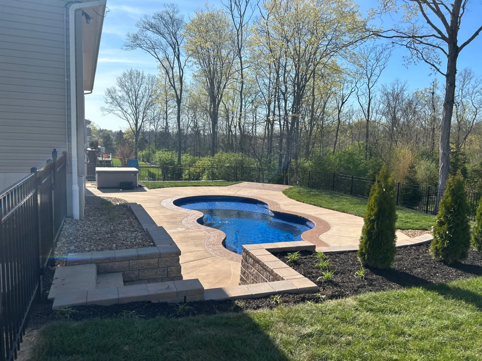 Freeform pool framed by segmental block walls and plantings