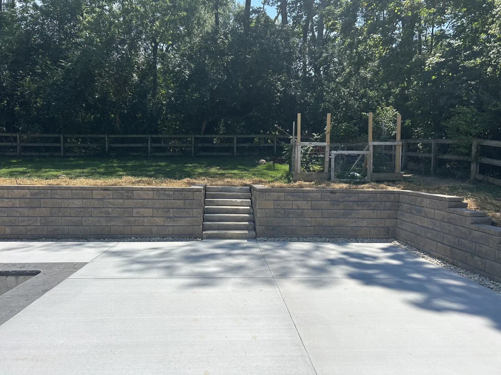 Block retaining walls with steps around a new pool deck