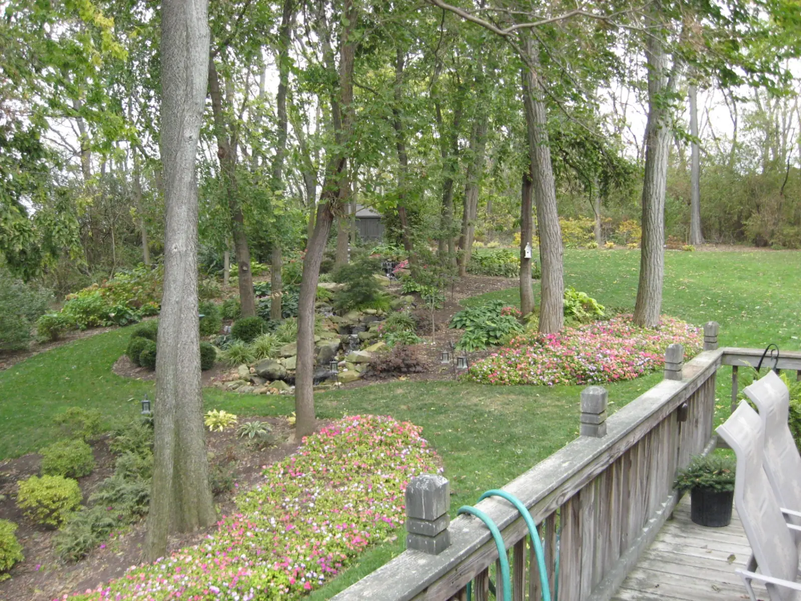 Natural stone stream and layered waterfall surrounded by planting