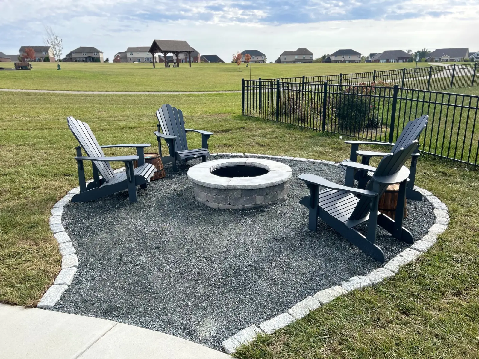 Stone fire pit and seating circle in a wooded backyard