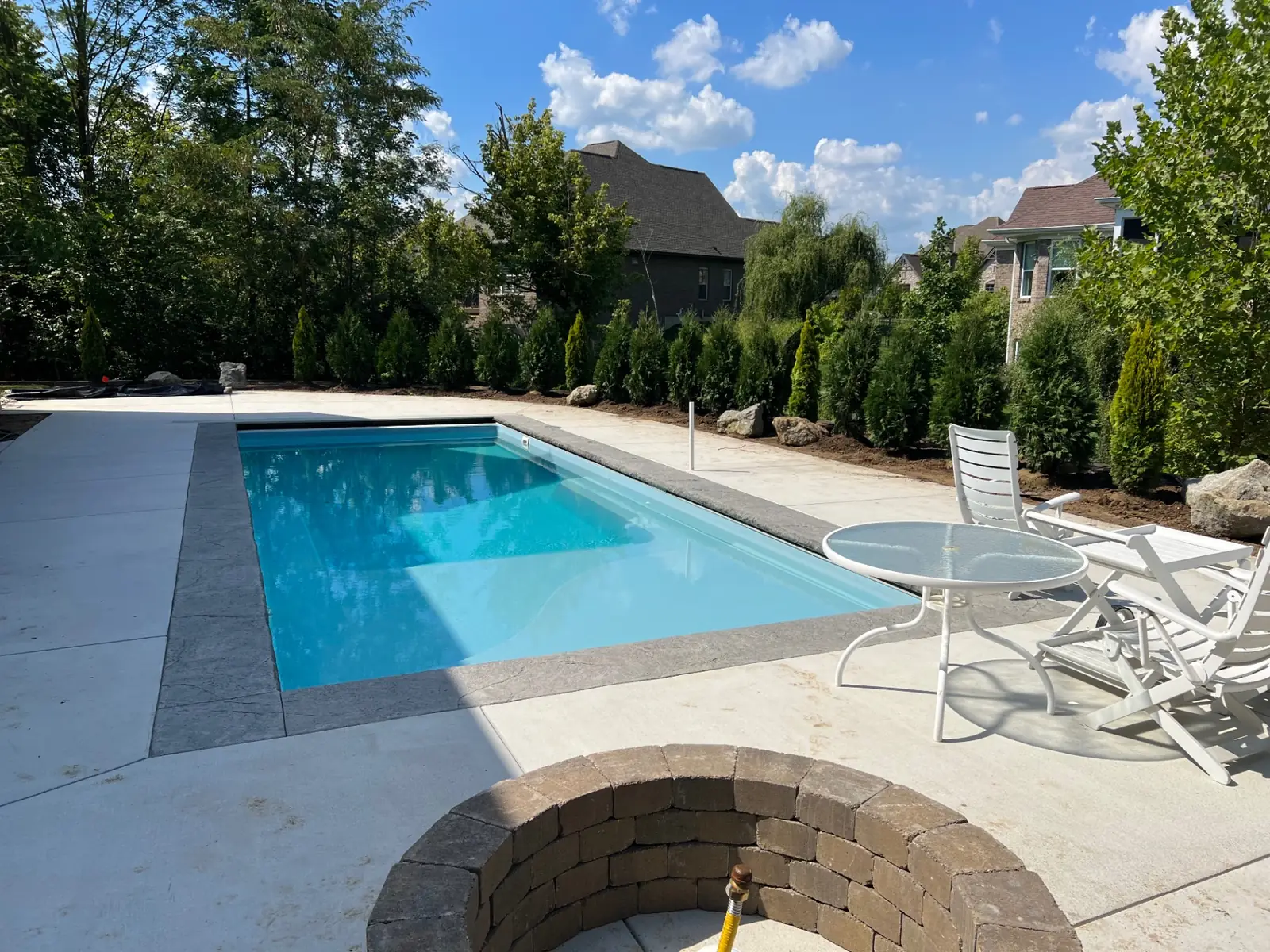 High-angle view of a rectangular pool and light concrete sun deck