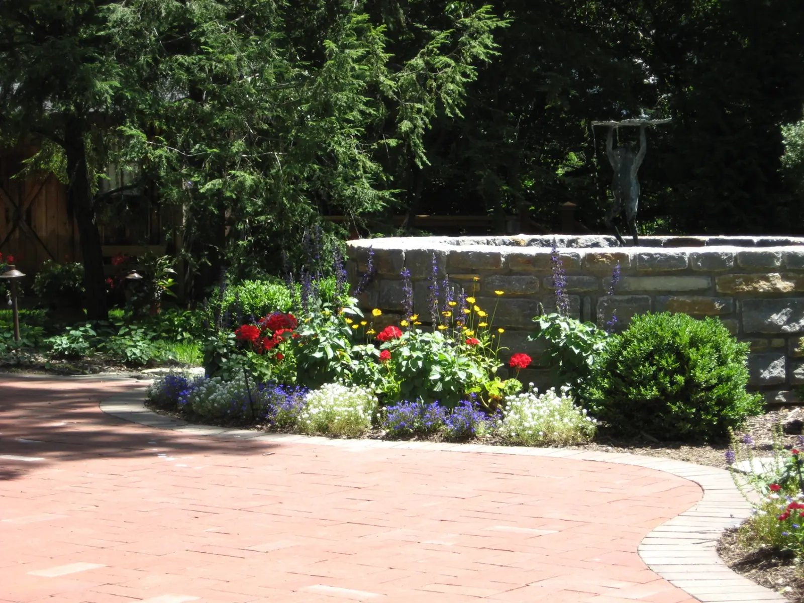 Formal courtyard landscape centered on a custom stone fountain