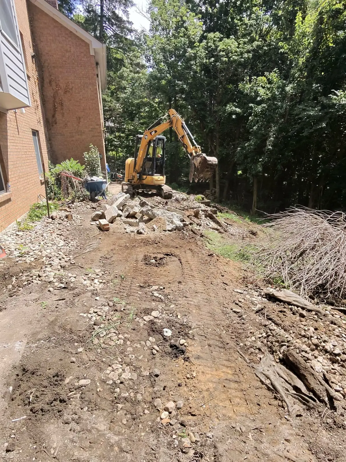 TJs crew operating a compact excavator during careful site preparation